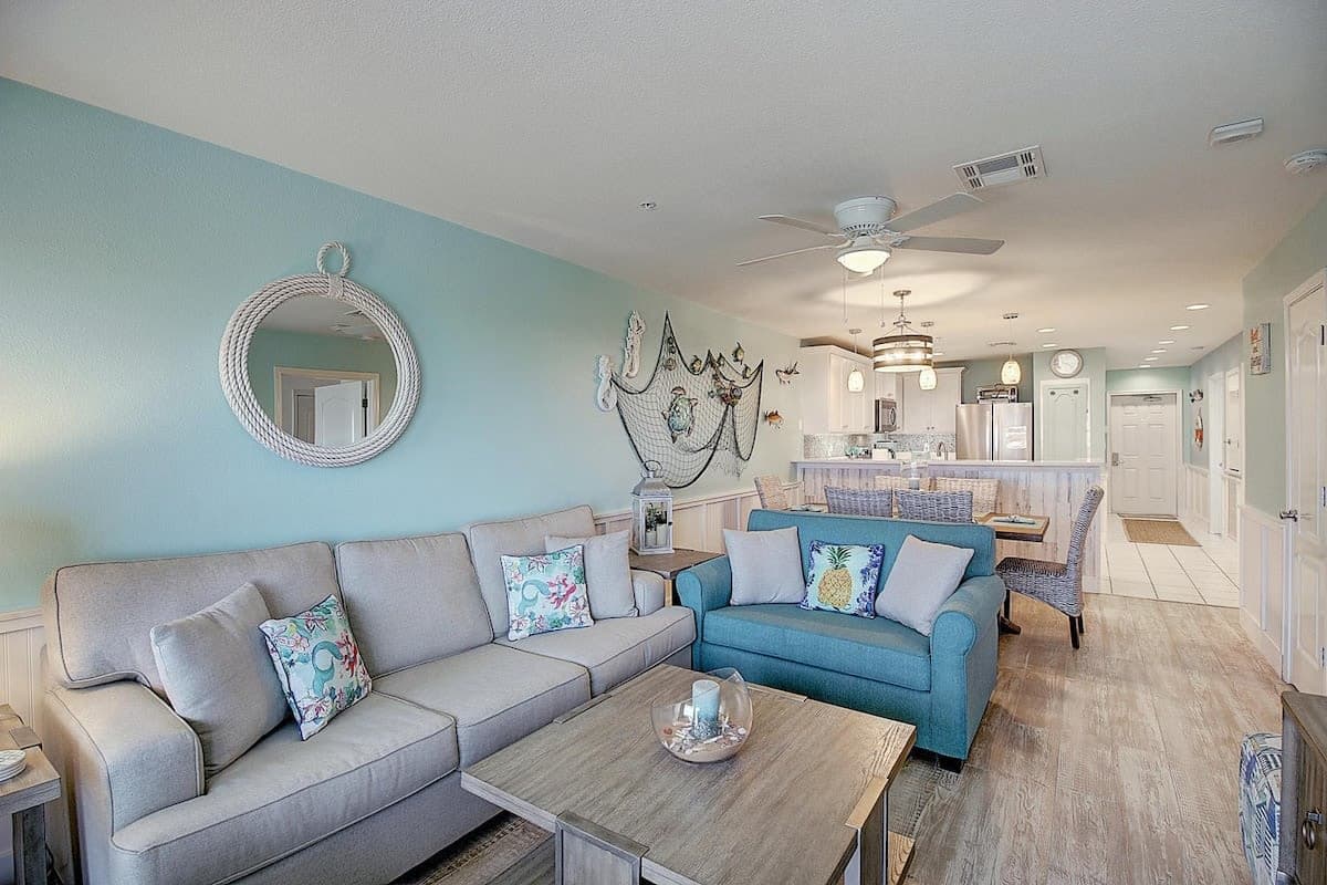 The open living and kitchen area at one of the Grand Caribbean condos, Port Aransas, with seafoam walls and coastal furnishings