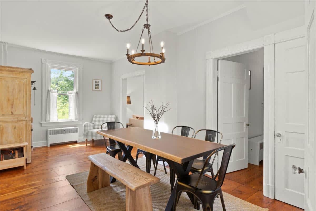 The dining room at 725 Route 66 with a live-edge table, bench, and iron chandelier